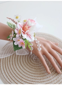 Détail d'un bracelet fleuri pour mariage avec marguerites et ruban en organza élégant