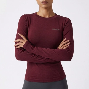 Détail d'un haut de sport à manches longues bordeaux avec texture côtelée sans couture