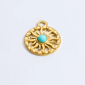 Detailed view of a gold sunburst pendant with a turquoise stone inlay on white background