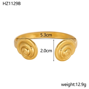 Detail of gold-plated stainless steel cuff bracelet with spiral design ends and 5.3cm diameter