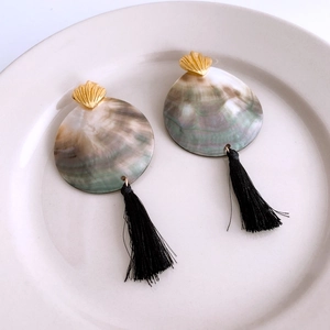Detail of round shell fringe earrings with natural mother of pearl and black silk tassels