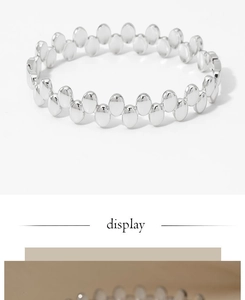 Detail view of the silver wavy oval link bracelet with high-polish metallic finish