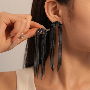 Side view of model wearing long black rhinestone fringe earrings in U-shaped design