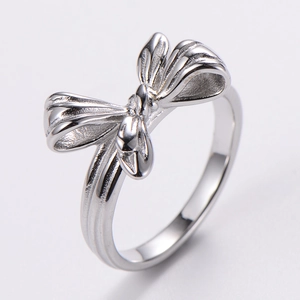 Macro shot of polished silver bow tie ring showing the smooth metallic finish and design