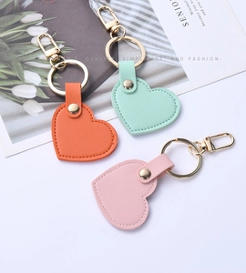 Detailed view of heart-shaped leather keychains in pink, orange, and mint green colors