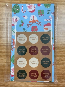 Close-up of Christmas gift bags set with festive stickers in protective clear packaging
