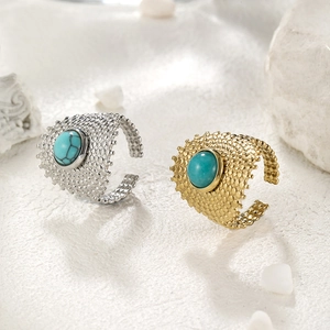 Detail view of gold and silver open rings with hollow mesh and green turquoise inlay