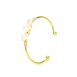 Detail of handmade gold wire-wrapped bracelet with three natural raw crystal stones
