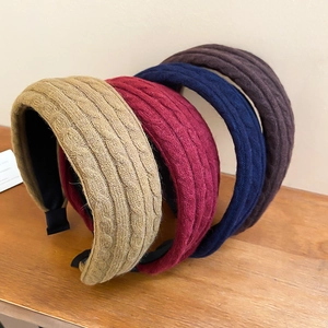 Détail de serre-têtes en maille torsadée en beige, rouge, marine et marron