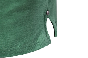 Detail of dark green polo shirt hem featuring pique cotton fabric and metal rivet