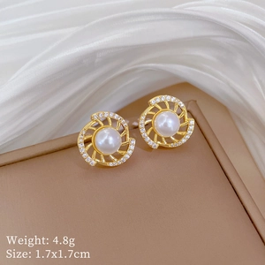 Macro shot of titanium gold spiral earrings with inlaid pearls and rhinestones on silk