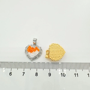 Detail view of 18K gold plated heart charms with zircons and ruler for size scale