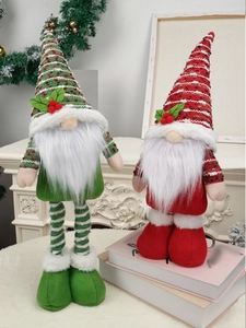 Details von Plüsch-Weihnachtswichteln mit Strickmützen und Beeren auf weichem Teppich