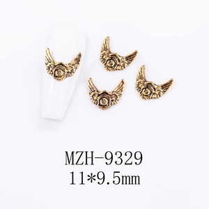 Detail of vintage gold alloy wing shield nail charm measuring 11x9.5mm with embossed design