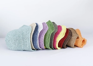 Close-up of flexible woven straw bucket hats displayed in a palette of twelve diverse colors