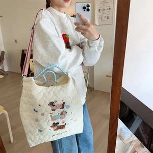 Mirror selfie showing soft heart-quilted crossbody bag with cute puppy embroidery