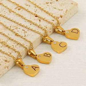 Dettaglio di ciondoli a cuore placcati oro 18k con lettere A B C D e piccoli zirconi