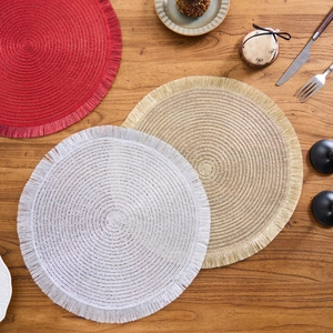 Detail of round woven placemats with tassel edges in red gold and white colors