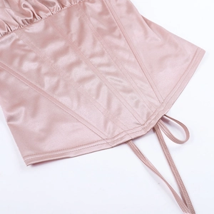 Dettaglio del corsetto in raso rosa con tessuto arricciato e cuciture di supporto steccate