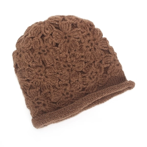 Close-up of caramel knit beanie showing 3D floral texture and thick rolled hem