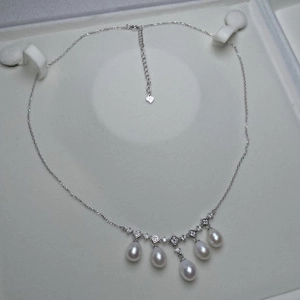 Dettaglio collana in argento con cinque perle a goccia in una scatola da regalo
