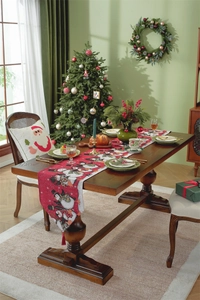 Detailed view of red Christmas table runner with snowman patterns on a wooden table