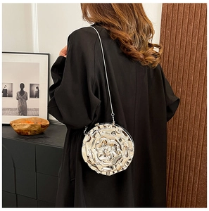 Silver rose petal clutch purse with metal chain worn by model over black dress