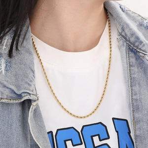 Close-up of 18K gold plated twisted rope chain necklace worn by a fashion model