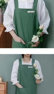 Detail of green washed cotton linen apron featuring wide shoulder straps and large front pocket