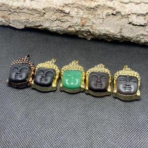 Detail view of crystal Buddha head pendants with gold and bronze metal trim accents
