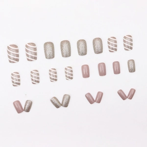 Faux ongles élégants champagne et rose avec paillettes et motifs à rayures diagonales