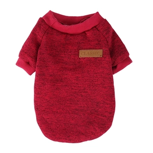 Detail eines roten Strickpullovers für Hunde mit klassischem Lederpatch und Rippbündchen