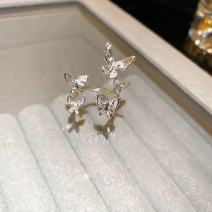 Detail of gold and silver plated butterfly ring with artificial pearls on grey velvet tray