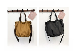 Detailed comparison of khaki and black vintage canvas messenger bags with metal rivets