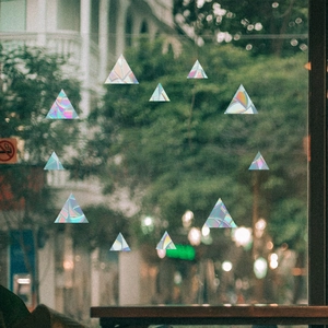 Macro detail of holographic rainbow triangle window clings in a circular pattern