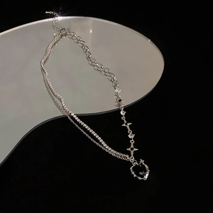 Detail shot of a double-layered necklace with a black heart pendant and sparkling rhinestones