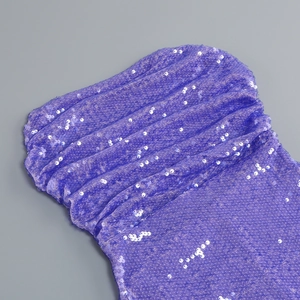 Dettaglio di paillettes viola e drappeggio sul corpetto dell'abito da festa sexy
