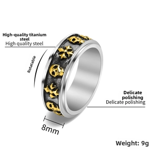 Detailed macro view of rotatable punk skull cross titanium steel ring with gold relief