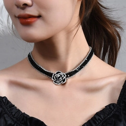 Detail shot of a titanium steel choker featuring a black rose pendant on a model's neck