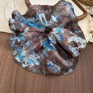 Detail of vintage marble pattern fabric scrunchie on dark wooden table background