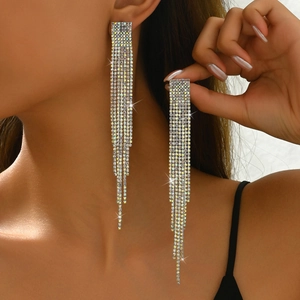 Close-up of long silver cascading rhinestone fringe earrings on model for gala events