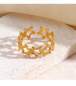 Detailansicht goldener Ring mit hohlen Sternen auf weißem Stein in weichem Licht