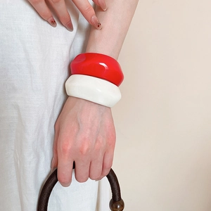 Macro detail of red and cream resin acrylic thick textured geometric bangle bracelets