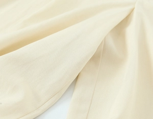 Gros plan détaillé du tissu beige du gilet et de la texture du pantalon plissé