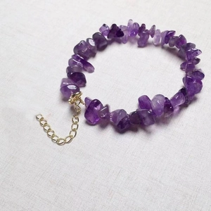 Makroaufnahme von natürlichen unregelmäßigen lila Amethyststeinen mit goldener Verlängerung