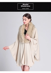 Detail view of the elegant faux fox fur collar on a cream knit poncho cardigan