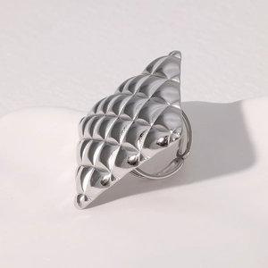 Macro shot of silver stainless steel ring featuring detailed diamond quilt textures