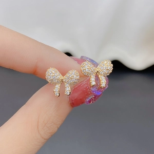 Macro shot of gold-plated bow stud earrings with sparkling pavé cubic zirconia