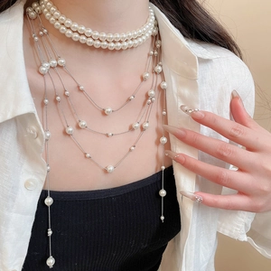 Detail view of multi-layered pearl necklace featuring silver chains and elegant white pearls