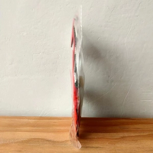 Close-up of a Christmas gnome cutlery holder in red and black stripes packed in a clear bag